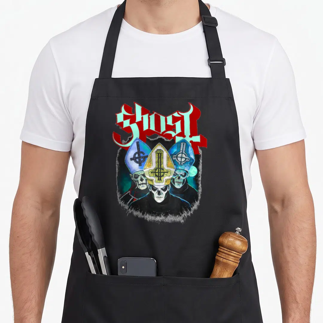 Trinity ghost apron - Arched GHOST text above three skeletal figures in mitres with red blue black yellow colors — shown on a black cotton canvas apron against a white background