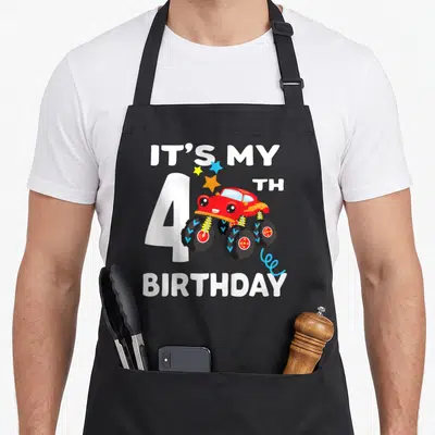 4yr truck apron - Red monster truck with IT'S MY 4TH BIRTHDAY text and white number 4 — shown on a black cotton canvas apron against a white background