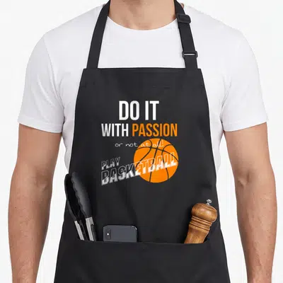 Passion apron or apron - DO IT WITH PASSION text over orange basketball with PLAY BASKETBALL overlay — shown on a black cotton canvas apron against a white background