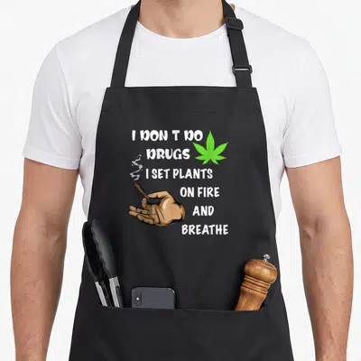 Drug pot apron - Cartoon hand holding smoking joint next to stacked white text and green leaf — shown on a black cotton canvas apron against a white background
