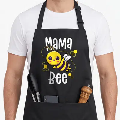 Mama family bee apron - Cartoon bee with yellow purple stripes and white Mama Bee text surrounded by honeycomb cells — shown on a black cotton canvas apron against a white background