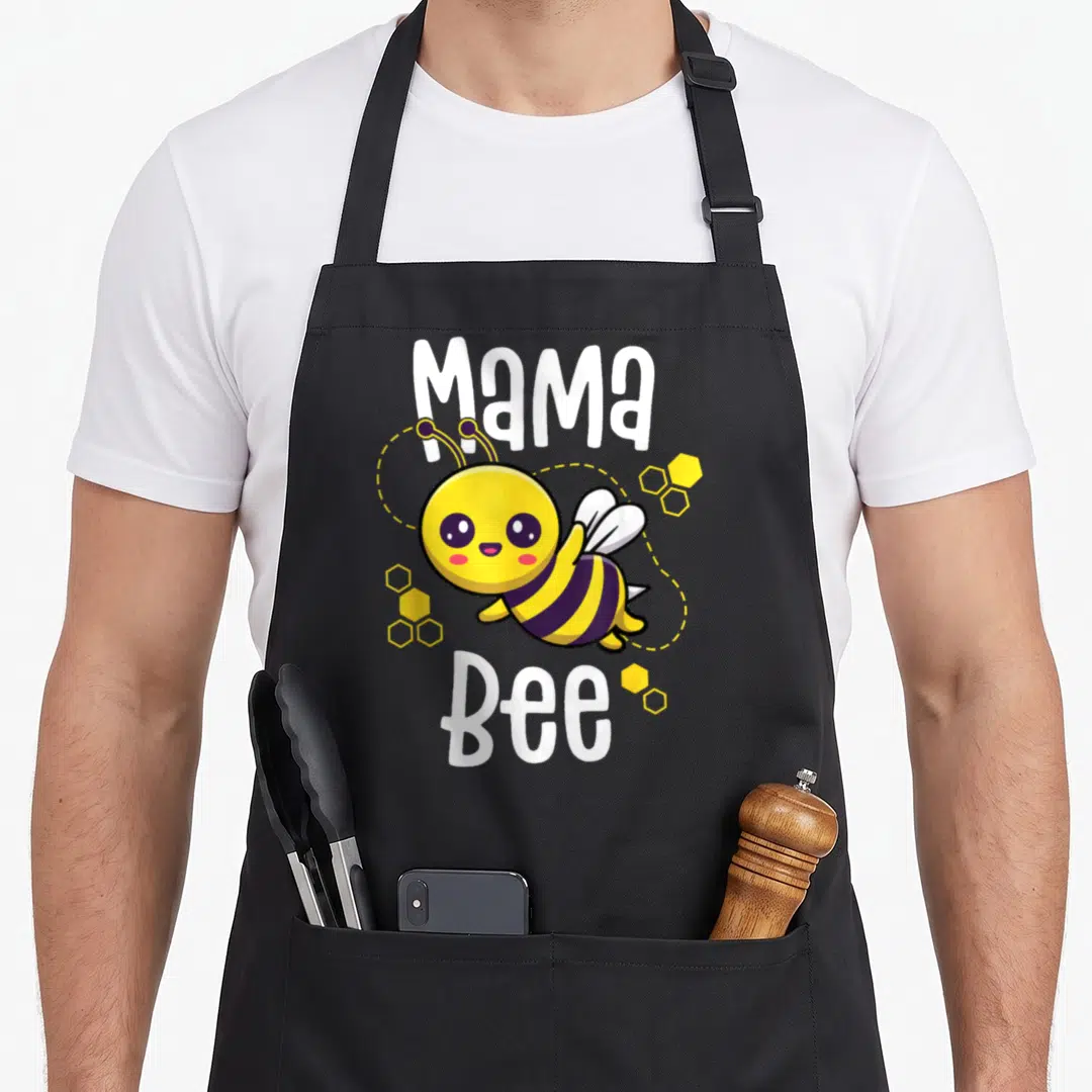 Mama family bee apron - Cartoon bee with yellow purple stripes and white Mama Bee text surrounded by honeycomb cells — shown on a black cotton canvas apron against a white background
