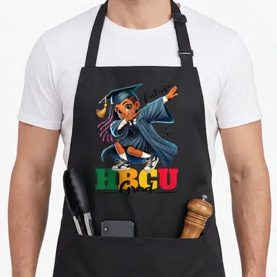 Afro motivational grade apron - Cartoon graduate girl with Future HBCU Grad text in blue green yellow red — shown on a black cotton canvas apron against a white background