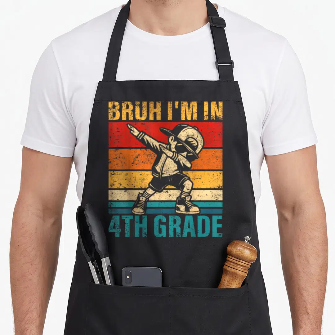 Grade student aprons - Dabbing boy on red orange yellow blue stripes with BRUH I'M IN 4TH GRADE text — shown on a black cotton canvas apron against a white background