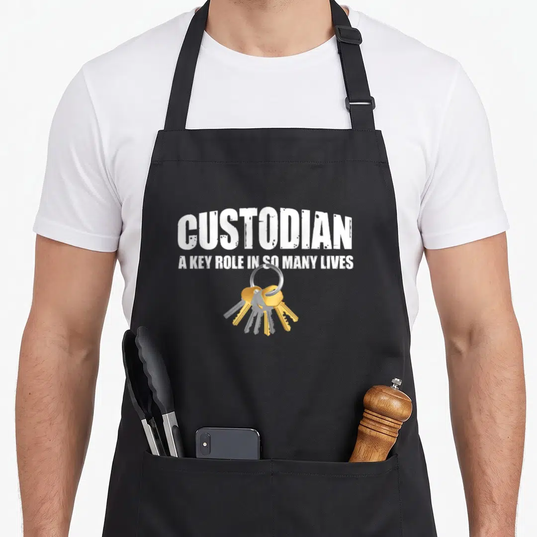 Custodian janitor apron - White text reading CUSTODIAN above gold keys on a silver ring — shown on a black cotton canvas apron against a white background