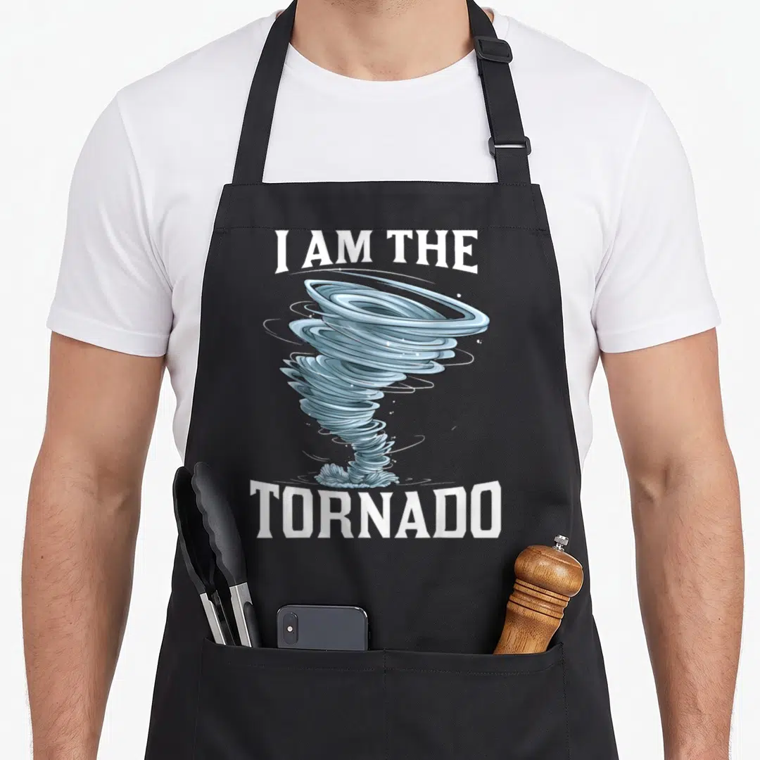 Meteorologist tornado apron - Blue cartoon tornado graphic between white 'I AM THE TORNADO' text on grey background — shown on a black cotton canvas apron against a white background