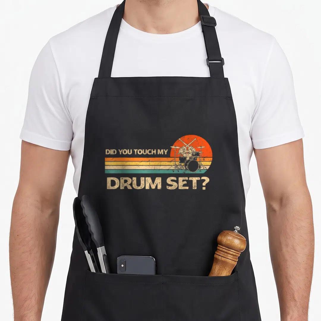 Touch drum apron - Retro drum set graphic with Did You Touch My Drum Set text over striped sun — shown on a black cotton canvas apron against a white background