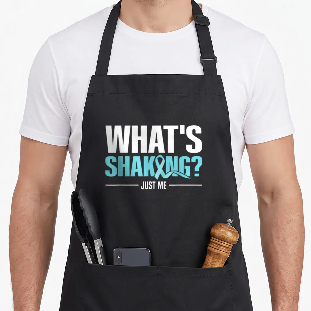 Supporter parkinsons awareness apron - White and blue text reading whats shaking just me with a ribbon replacing — shown on a black cotton canvas apron against a white background