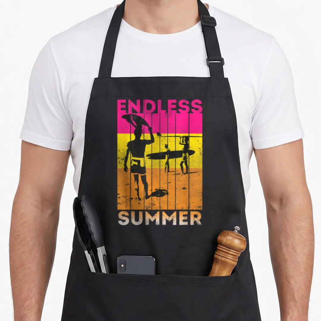 Endless summer aprons - Retro surfer silhouettes on pink yellow orange bands with endless summer text — shown on a black cotton canvas apron against a white background