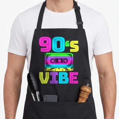 Music 90s apron - Colorful cassette tape with 90s VIBE text in pink blue yellow green purple retro style — shown on a black cotton canvas apron against a white background