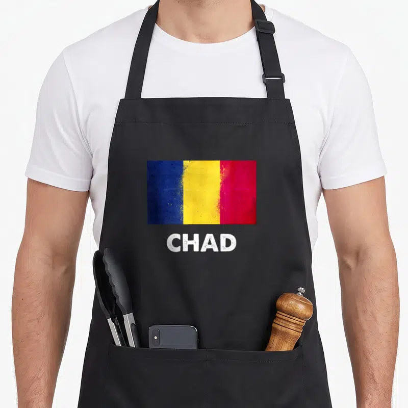 Jersey chad apron - Distressed blue yellow red flag above white CHAD text — shown on a black cotton canvas apron against a white background