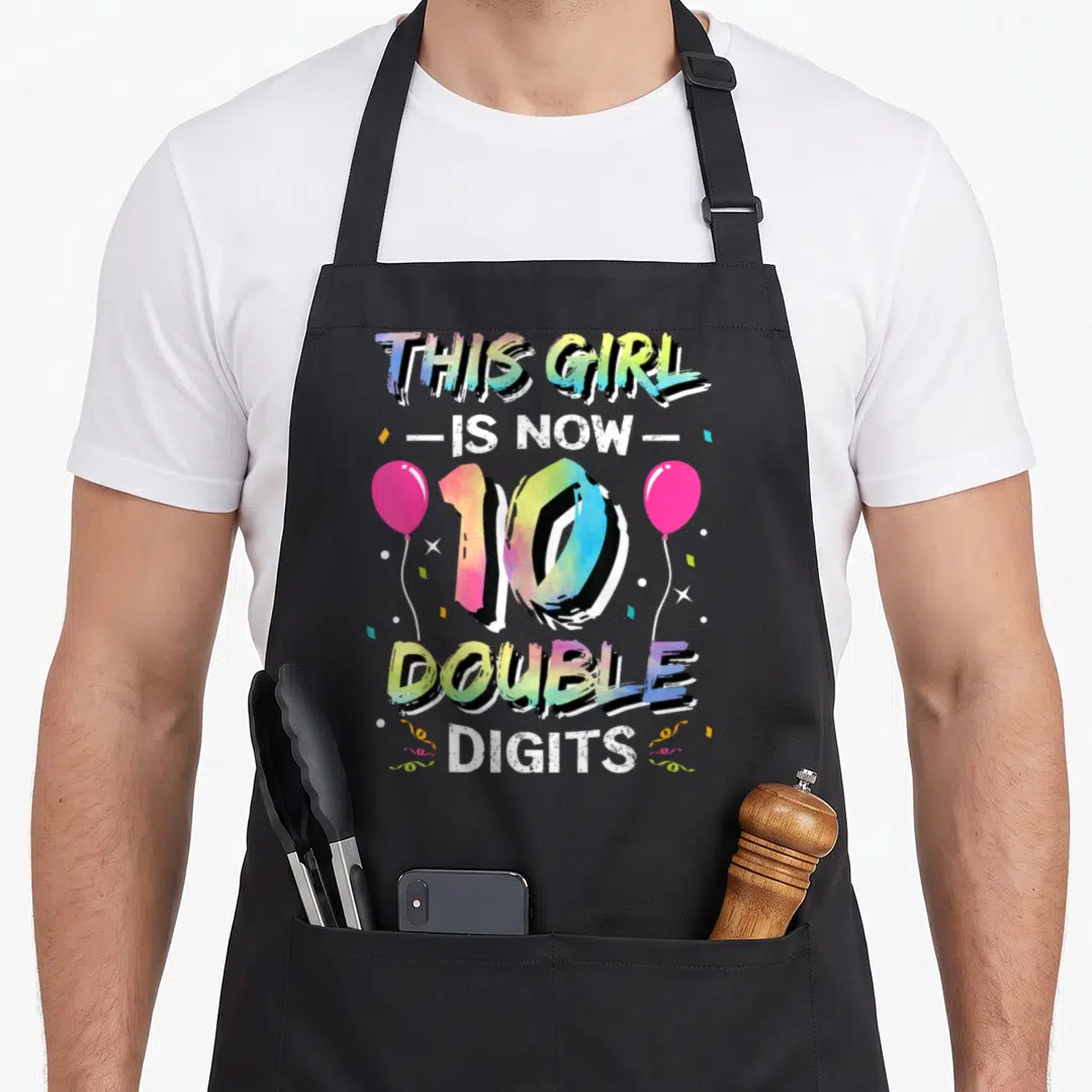 Vintage double birthday apron - Rainbow 10 text with pink balloons and confetti celebrating 10th birthday milestone — shown on a black cotton canvas apron against a white background