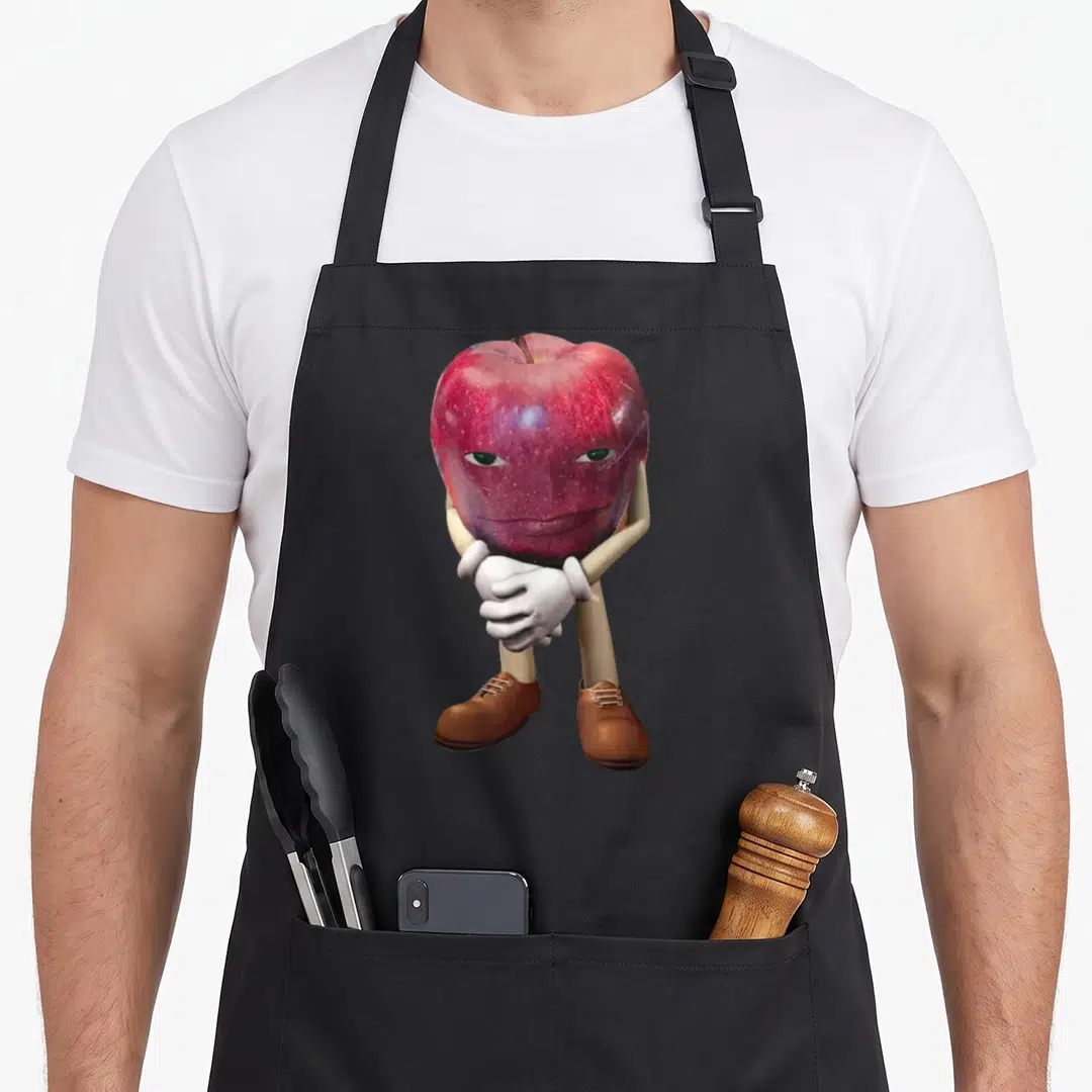 Asf apple apron - Red apple character with face, white gloves, and brown shoes standing centrally — shown on a black cotton canvas apron against a white background