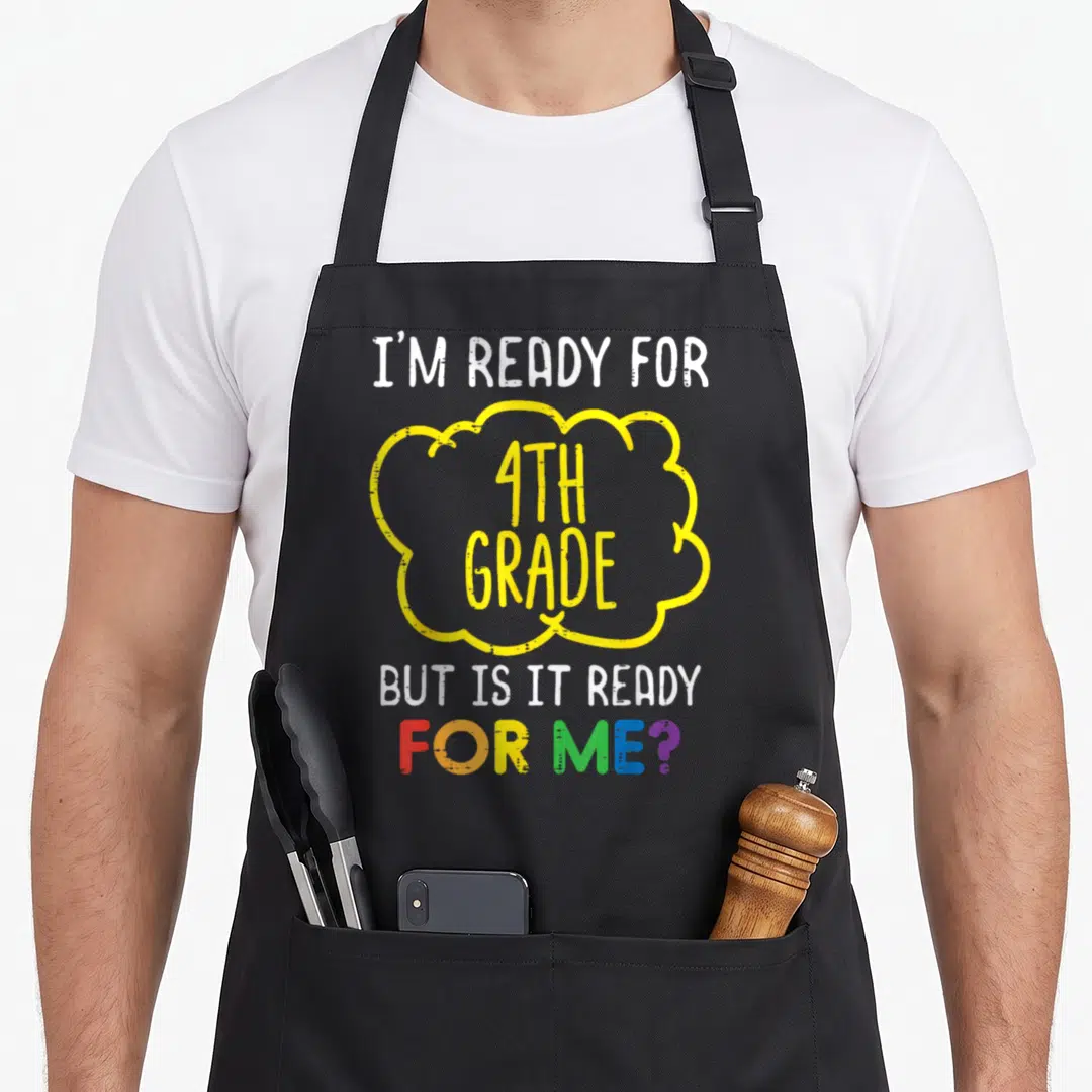 Ready grade fourth apron - Text reading I'm Ready for 4th Grade But Is It Ready For Me in white yellow and rainbow — shown on a black cotton canvas apron against a white background