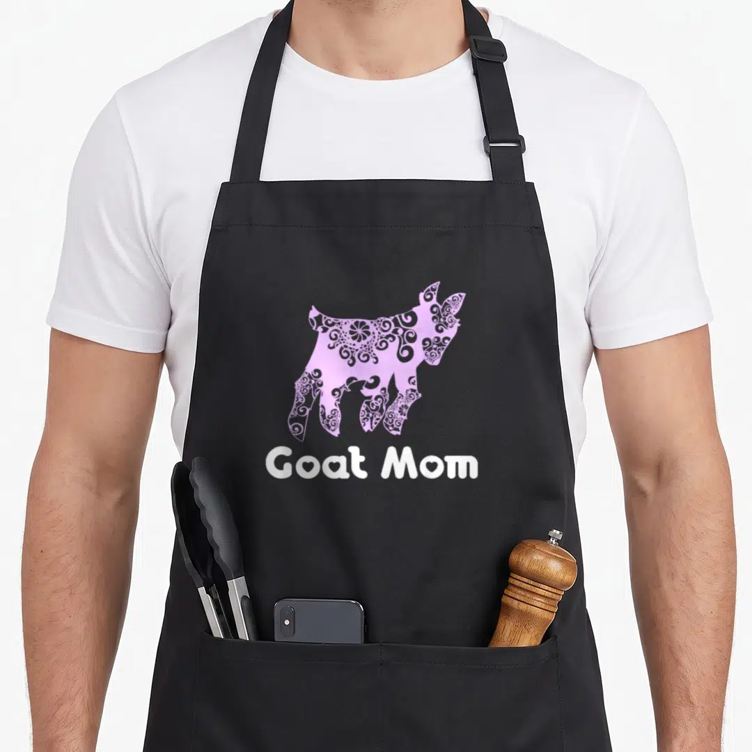 Pygmy goat aprons - Purple patterned goat silhouette above white Goat Mom text — shown on a black cotton canvas apron against a white background