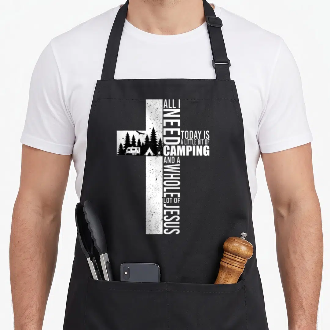 Today camping apron - Distressed white cross with camping scene and text reading All I Need Today Is A Little Bit — shown on a black cotton canvas apron against a white background