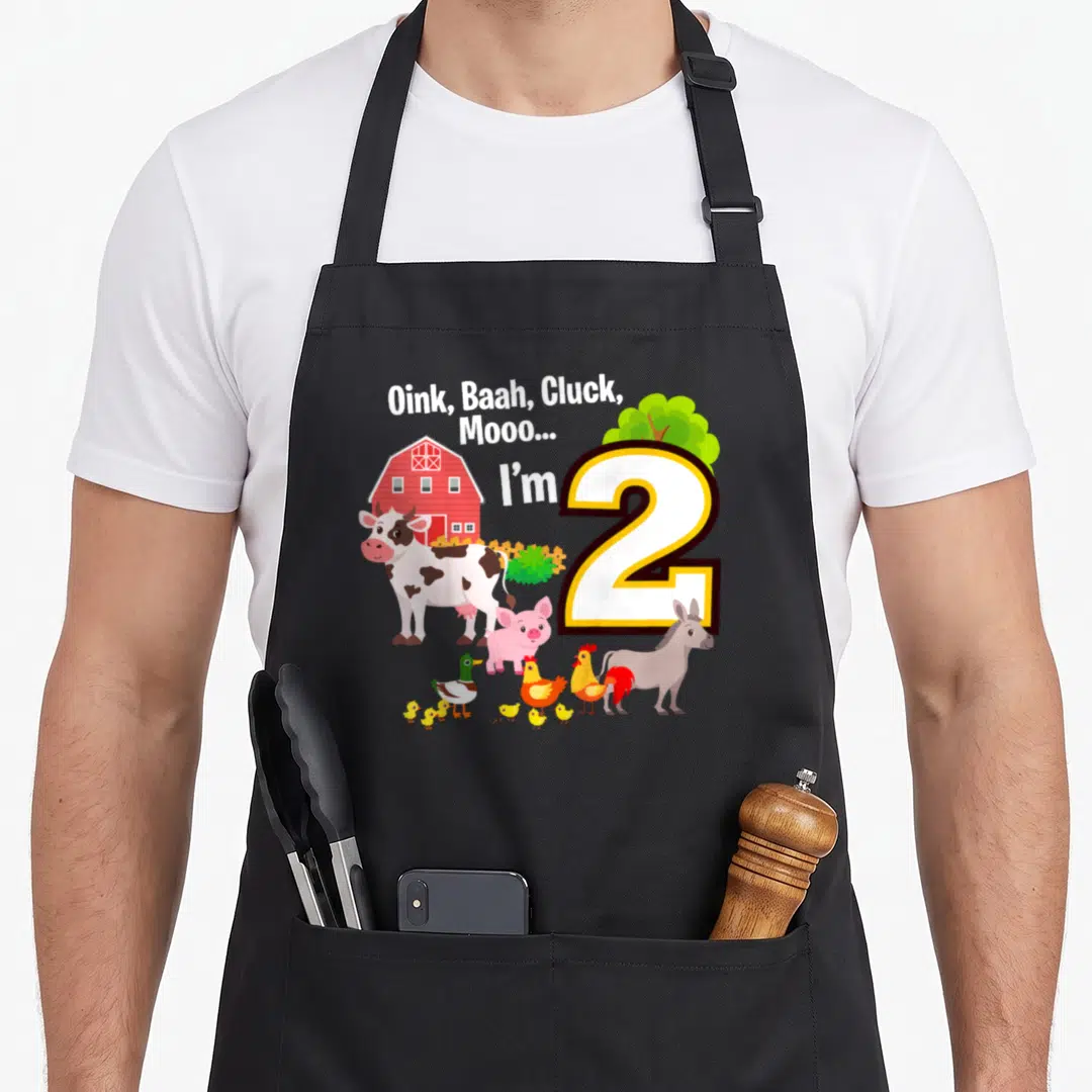 2nd farm aprons - Oink Baah Cluck Mooo I'm 2 with cow pig donkey roosters ducks barn and tree — shown on a black cotton canvas apron against a white background