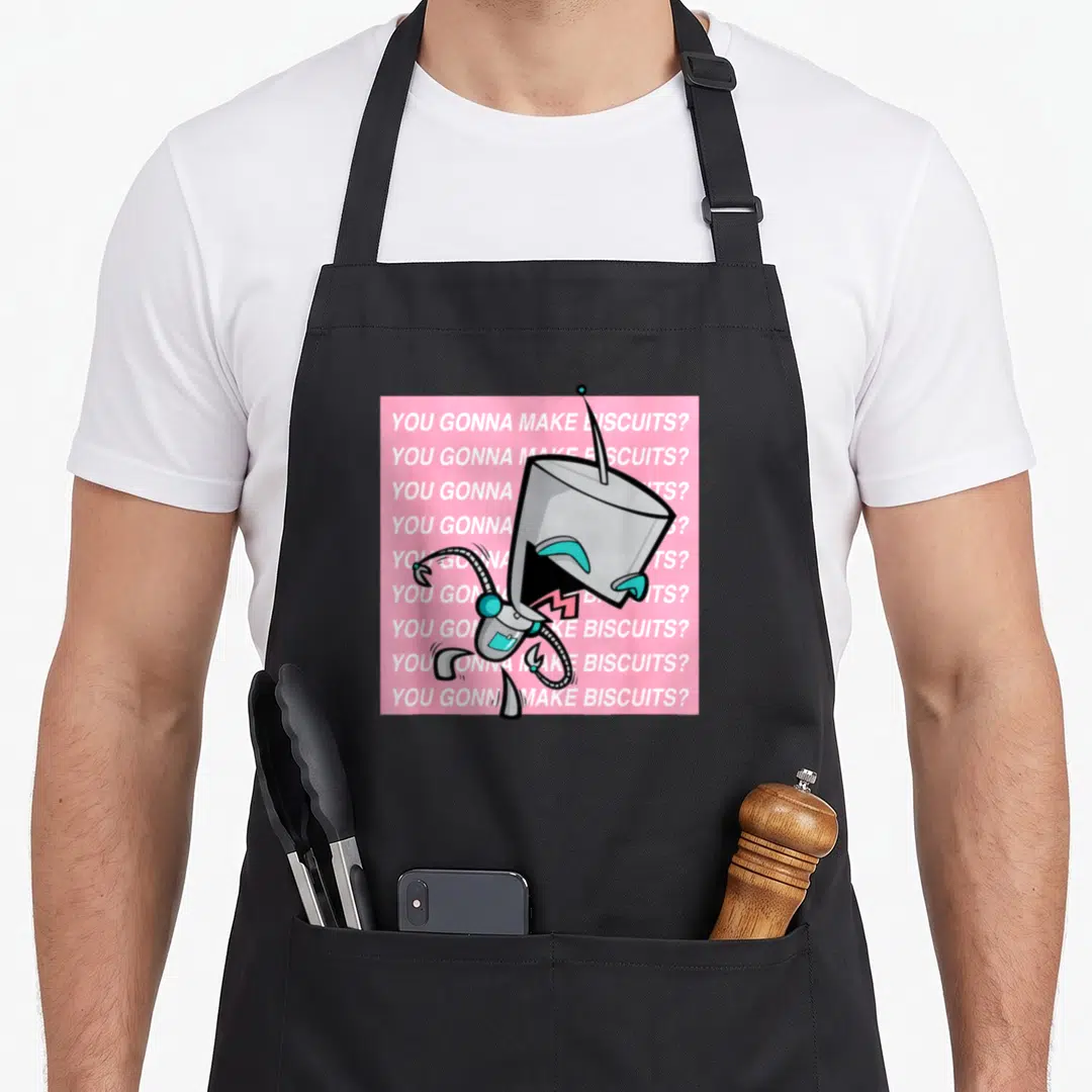 Invader crackers apron - Grey robot with teal eyes on pink background with repeated white text — shown on a black cotton canvas apron against a white background