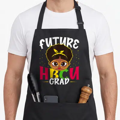 Hbcu grade girls apron - Cartoon girl with afro and yellow glasses between FUTURE HBCU GRAD text with scattered stars — shown on a black cotton canvas apron against a white background
