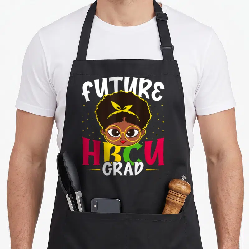 Hbcu grade girls apron - Cartoon girl with afro and yellow glasses between FUTURE HBCU GRAD text with scattered stars — shown on a black cotton canvas apron against a white background