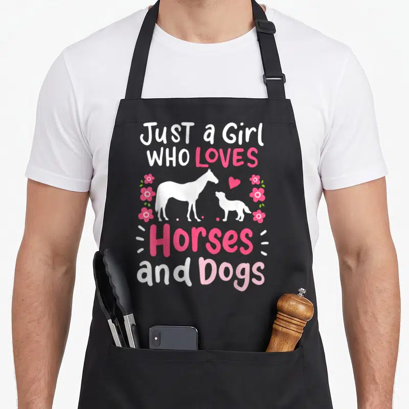 Dog horse apron - Pink and white text Just a Girl Who Loves Horses and Dogs with horse and dog silhouettes — shown on a black cotton canvas apron against a white background