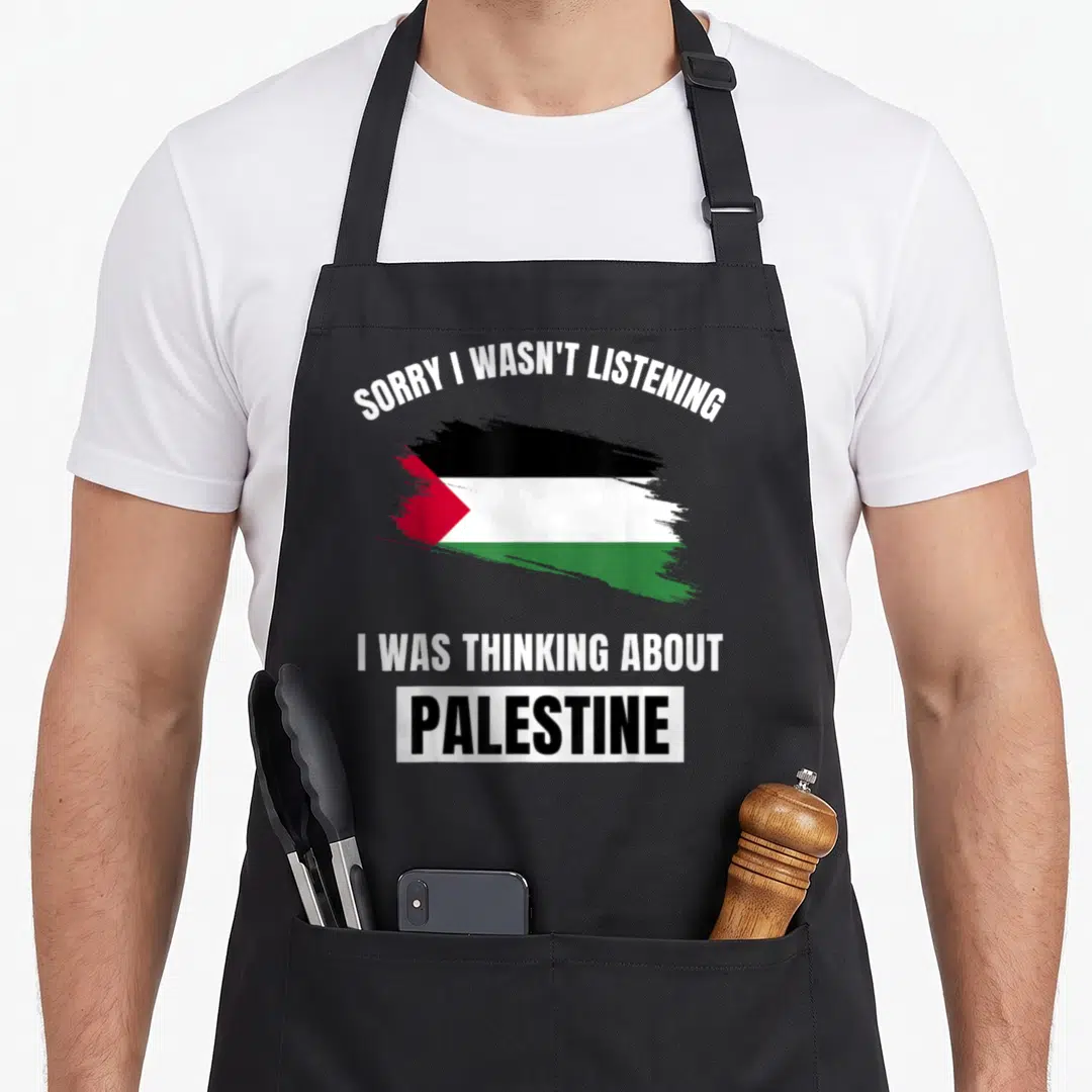 Sorry palestine apron - Brush stroke flag in black white green red with sorry I was not listening thinking about — shown on a black cotton canvas apron against a white background