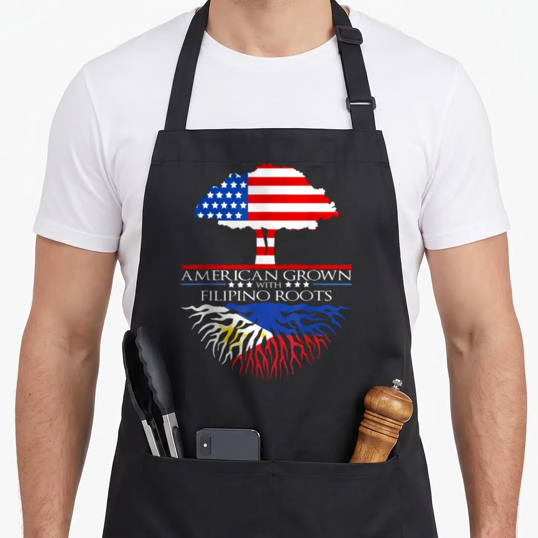 Tree philippine american flag apron - Tree with US flag canopy and Philippine flag roots above AMERICAN GROWN — shown on a black cotton canvas apron against a white background