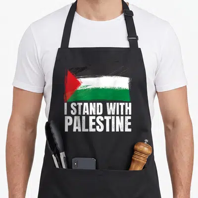 Palestine palestinian apron - Distressed Palestinian flag with I STAND WITH PALESTINE text in white block letters — shown on a black cotton canvas apron against a white background