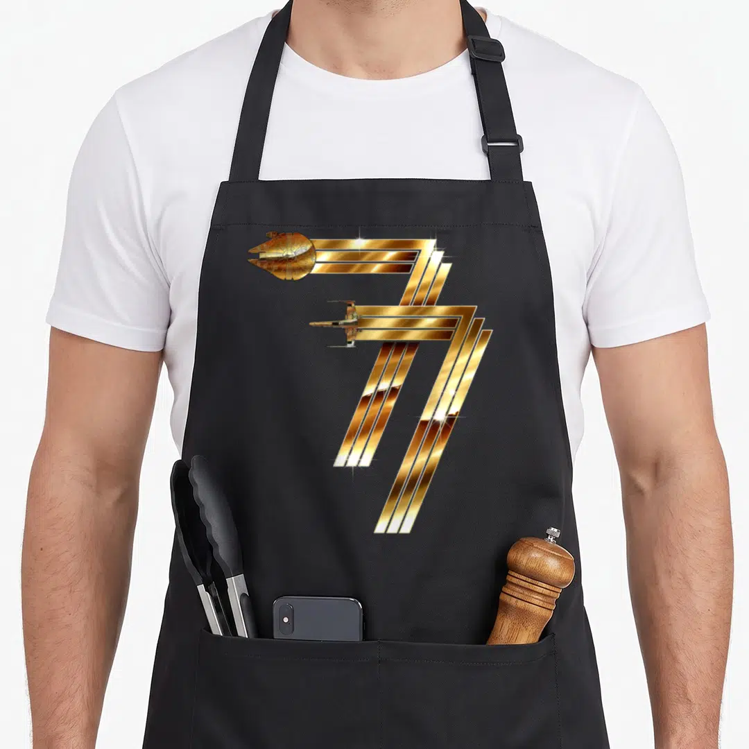 Spacecraft falcon apron - Two gold spacecraft integrated into diagonal stripes forming a geometric shape — shown on a black cotton canvas apron against a white background