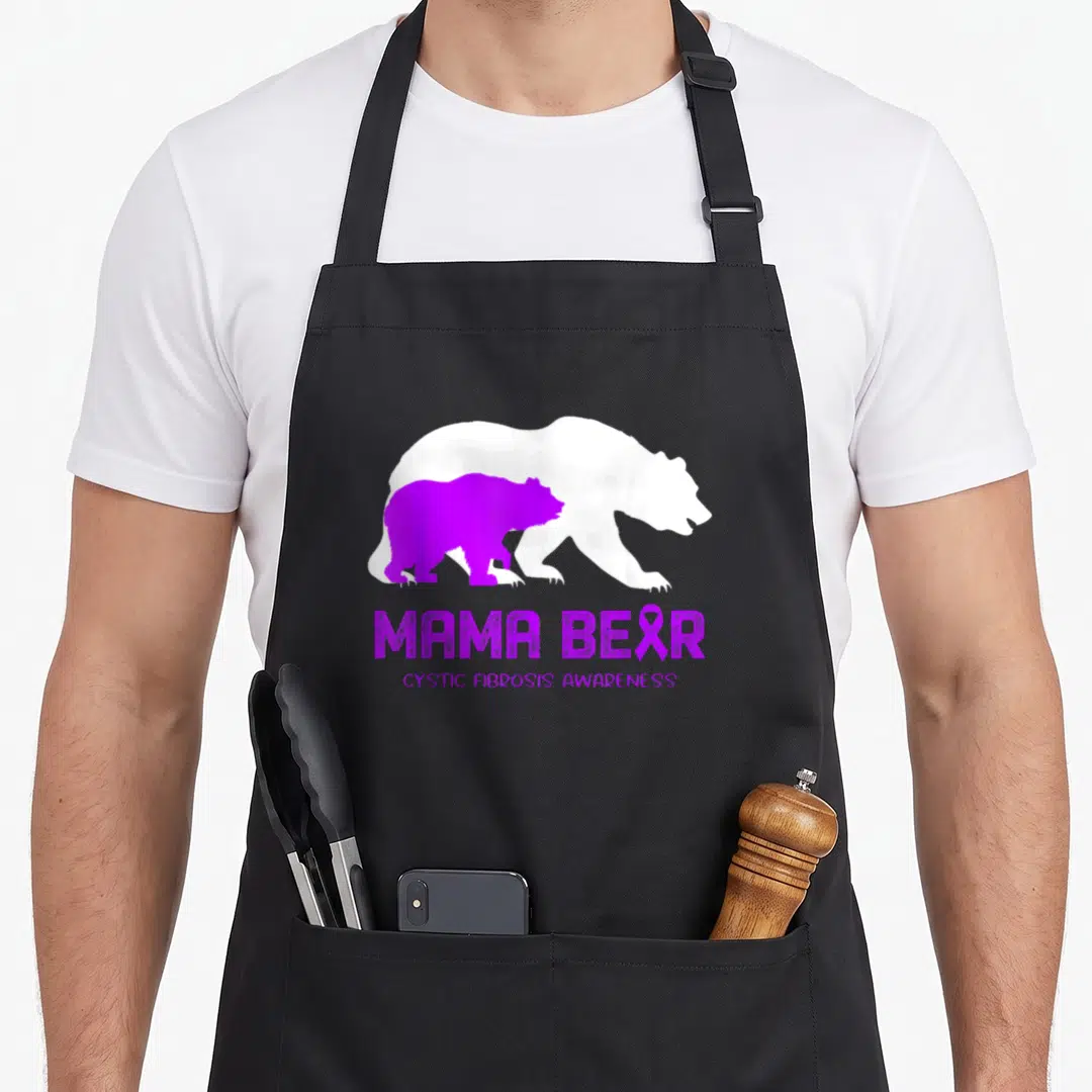 Cystic mama bear apron - Purple and white bear silhouettes with MAMA BEAR text and ribbon — shown on a black cotton canvas apron against a white background