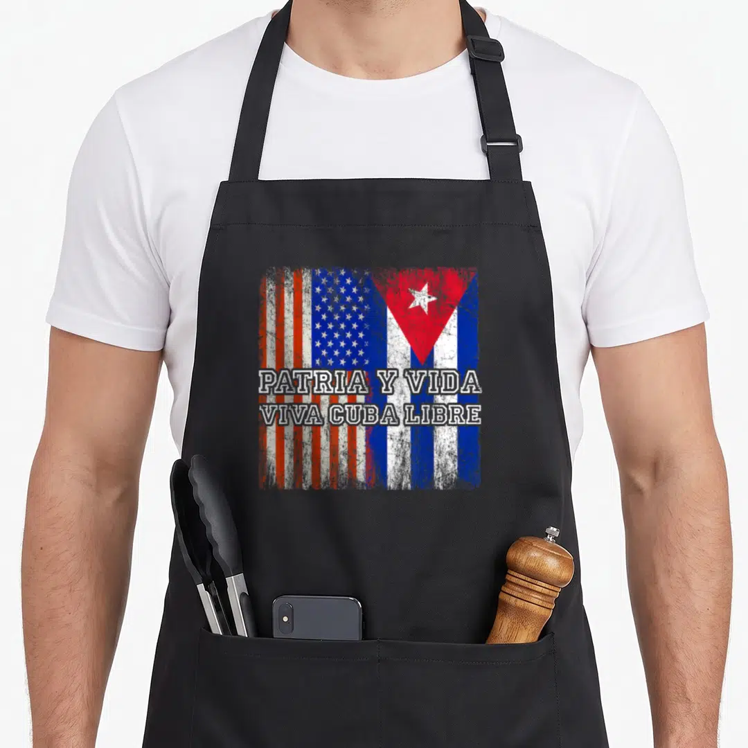 Patria pride apron - Merged US and Cuba flags with PATRIA Y VIDA VIVA CUBA LIBRE text in distressed red white blue — shown on a black cotton canvas apron against a white background