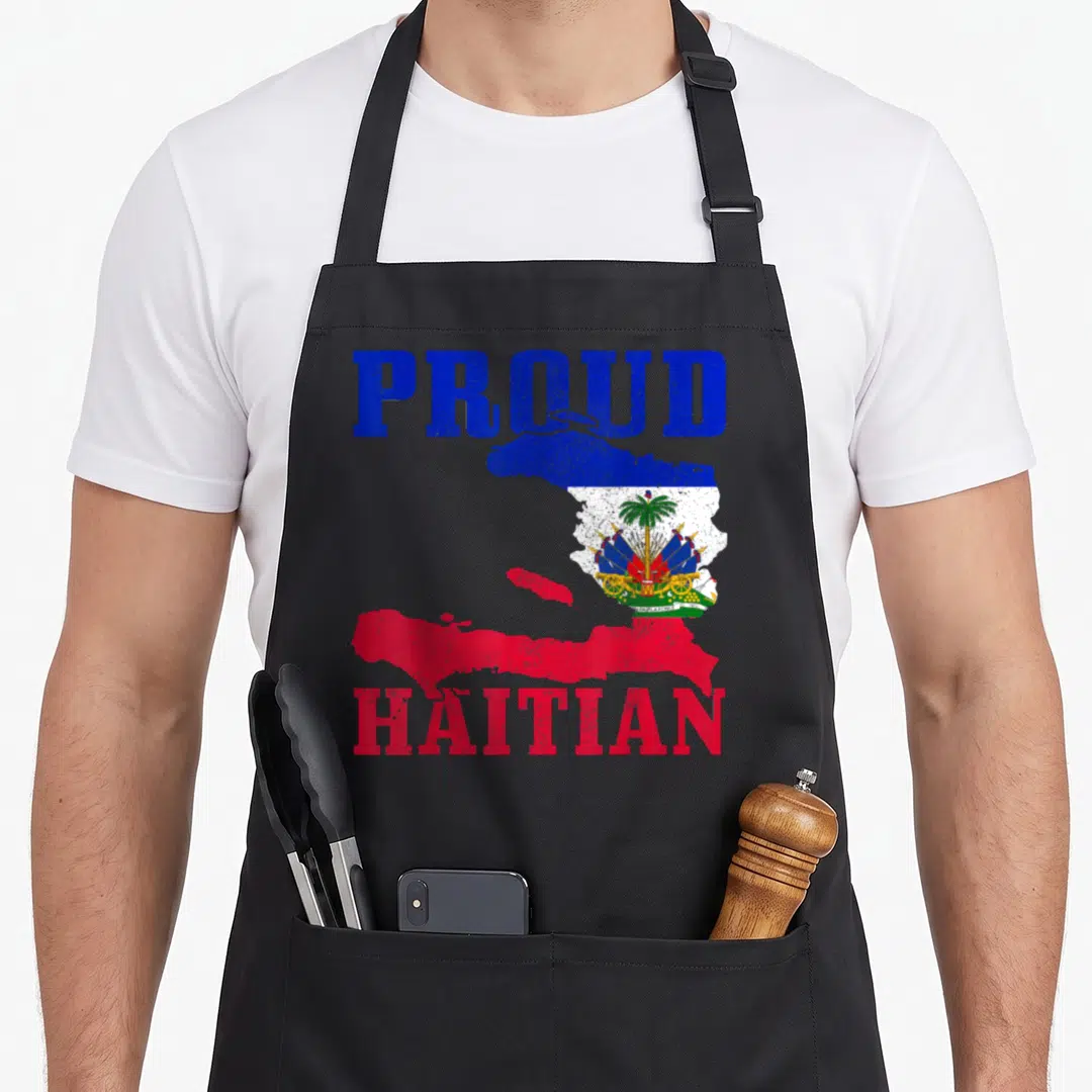Haiti proud pride apron - Distressed PROUD HAITIAN text framing a map of Haiti filled with the flag's blue red white — shown on a black cotton canvas apron against a white background