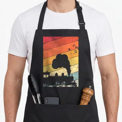 Steam train apron - Grey steam locomotive silhouette on red orange yellow blue grey diagonal stripes retro design — shown on a black cotton canvas apron against a white background