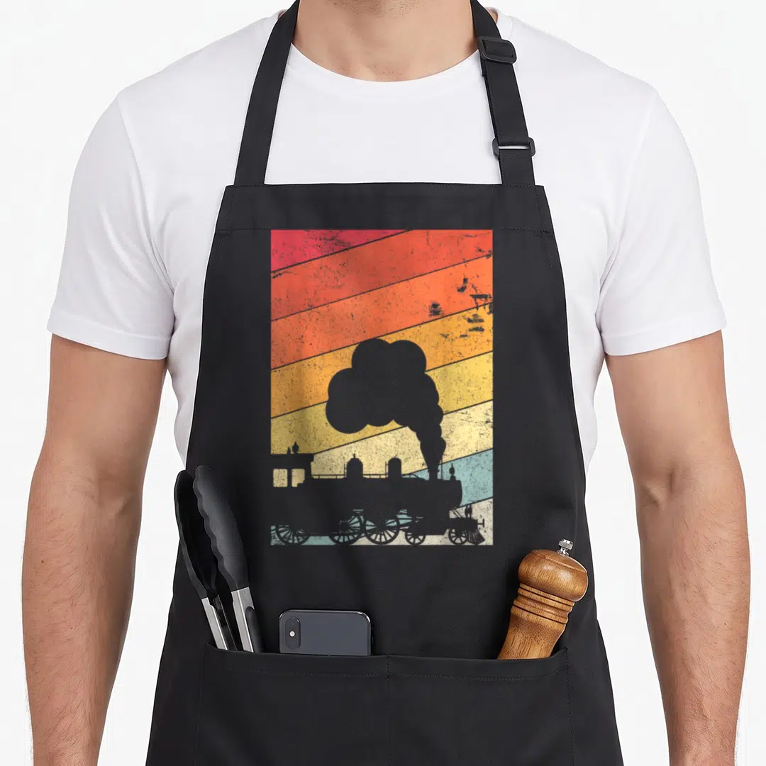 Steam train apron - Grey steam locomotive silhouette on red orange yellow blue grey diagonal stripes retro design — shown on a black cotton canvas apron against a white background