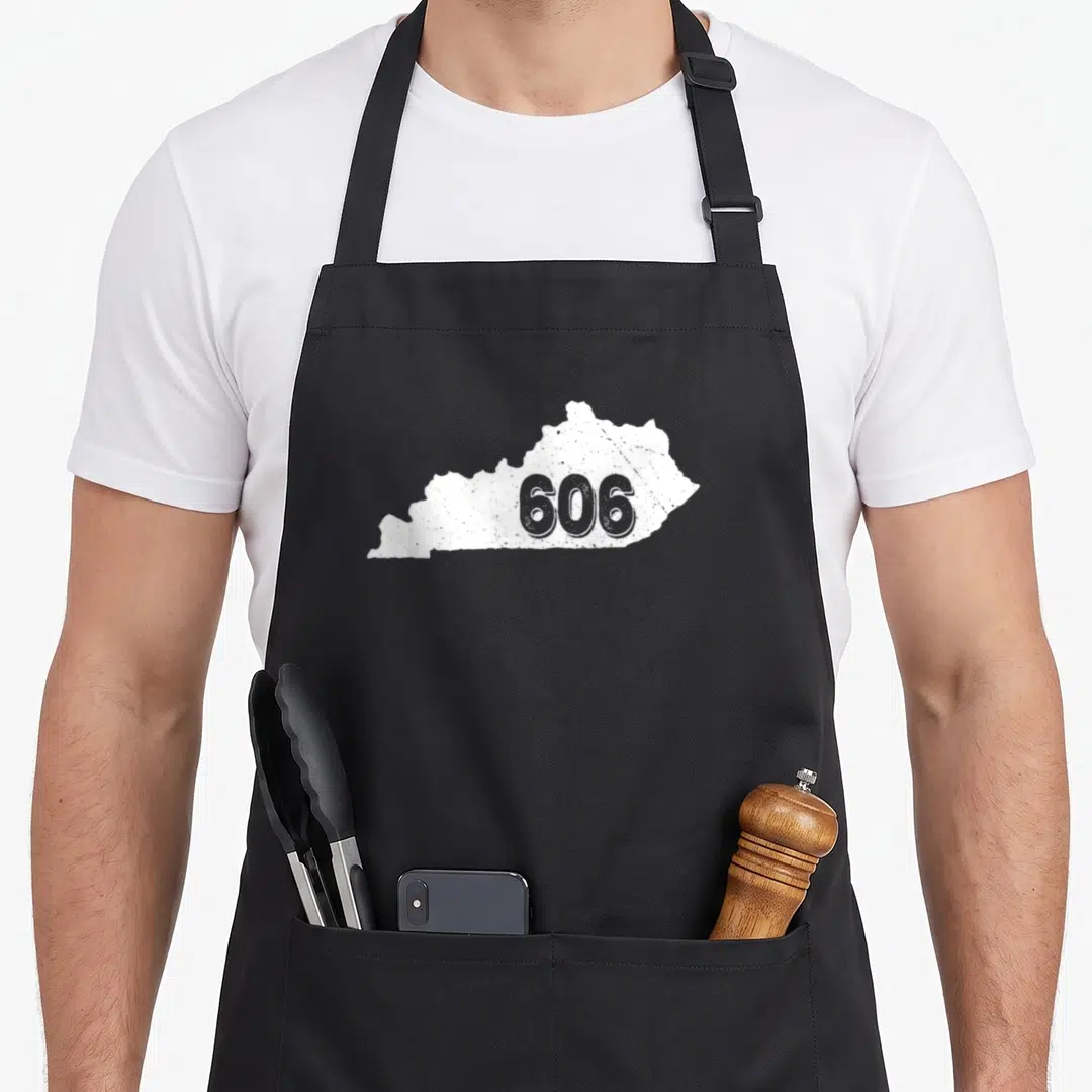 Area kentucky apron - White distressed Kentucky map silhouette containing the number 606 in the center — shown on a black cotton canvas apron against a white background