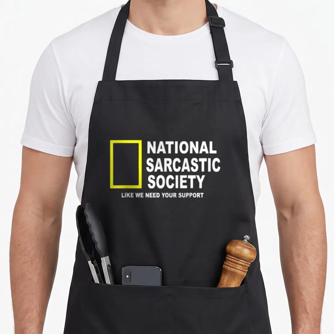 National sarcastic apron - Yellow rectangle next to stacked white text National Sarcastic Society Like We Need Your — shown on a black cotton canvas apron against a white background