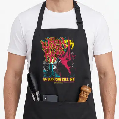 Lotr heavy metal apron - Red Witch-king helmet silhouette beside stacked yellow THE WITCH KING text and NO MAN CAN KILL — shown on a black cotton canvas apron against a white background