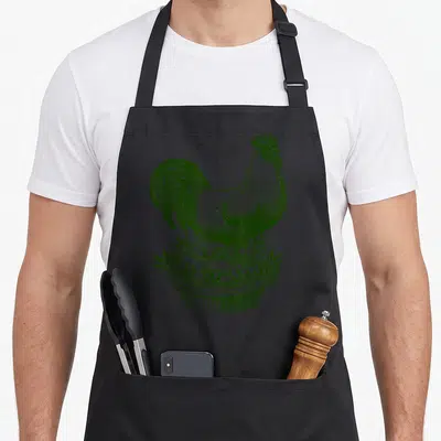 Ray pie apron - Green line art of a rooster standing on a pie crust filled with cannabis leaves — shown on a black cotton canvas apron against a white background