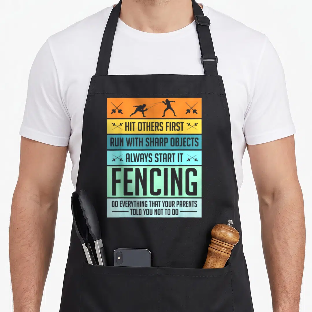 Pun fencing apron - Vertical stack of orange, blue, green bands with grey fencer silhouettes and fencing quotes — shown on a black cotton canvas apron against a white background
