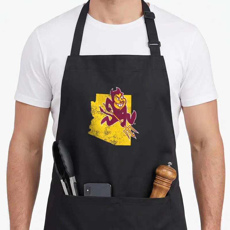Shape devil's apron - Maroon cartoon devil holding pitchfork in front of yellow Arizona state outline — shown on a black cotton canvas apron against a white background