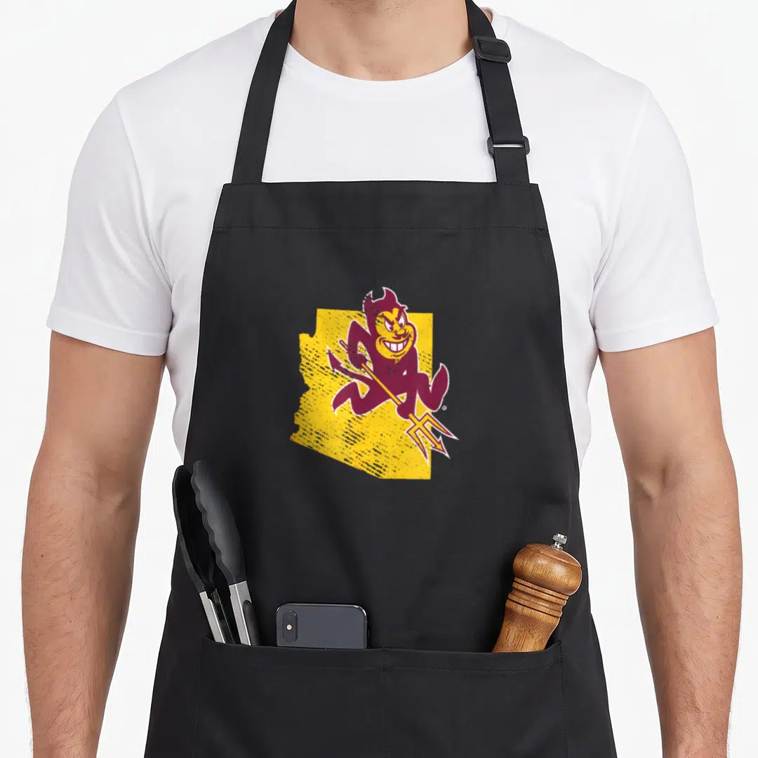 Shape devil's apron - Maroon cartoon devil holding pitchfork in front of yellow Arizona state outline — shown on a black cotton canvas apron against a white background