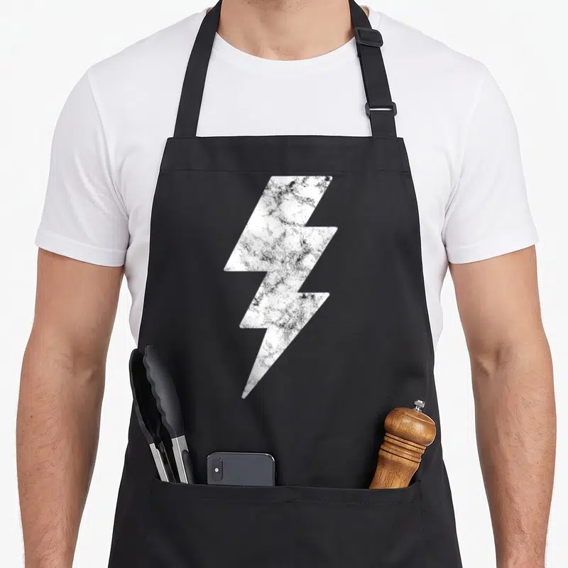 Funny lightning lighting bolt apron - Distressed white lightning bolt graphic centered on grey background — shown on a black cotton canvas apron against a white background