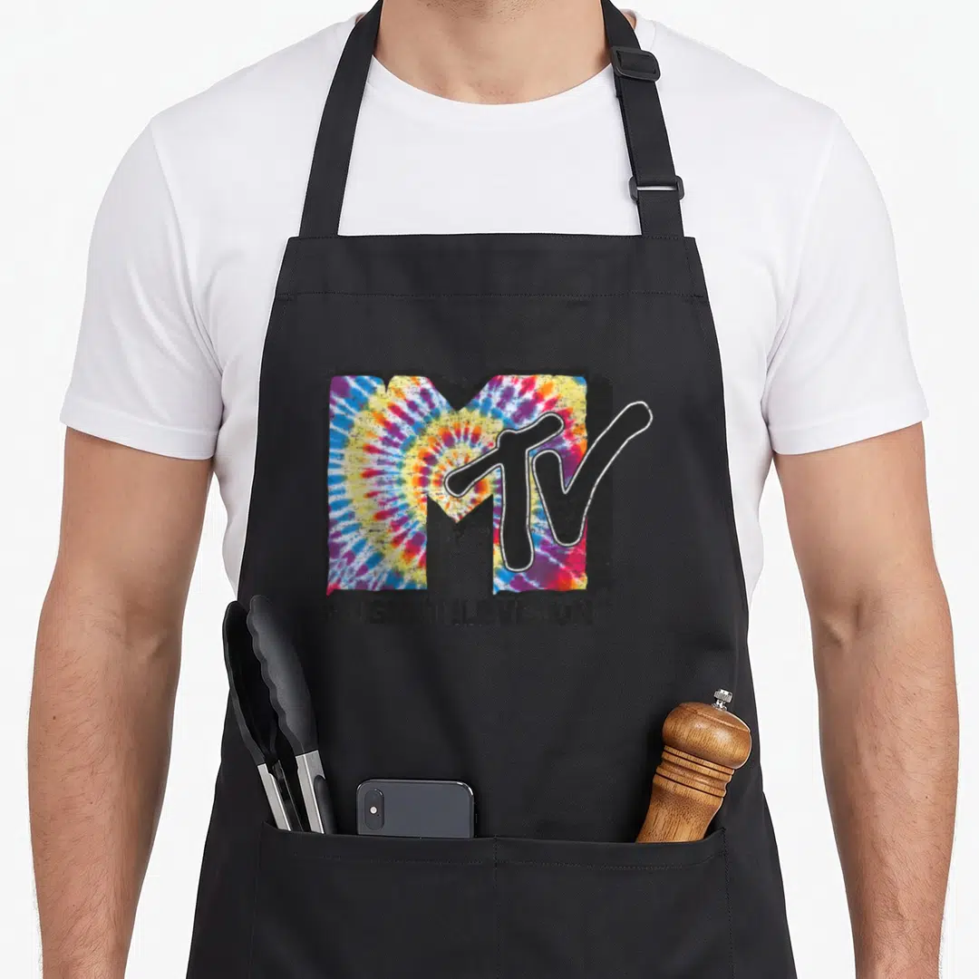 Mtv tie dye apron - MTV logo with tie-dye fill and MUSIC TELEVISION text in distressed style — shown on a black cotton canvas apron against a white background