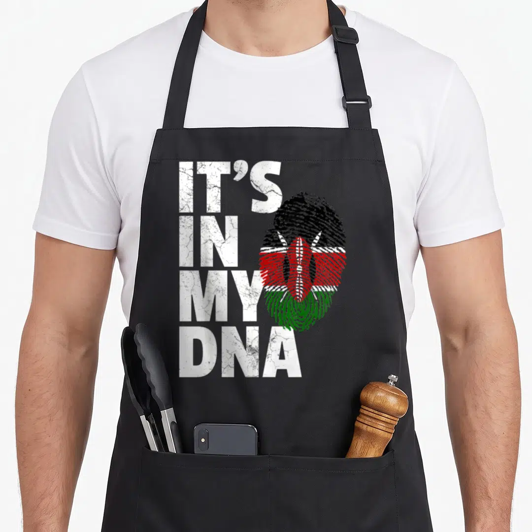 Dna kenyan boy apron - Stacked IT'S IN MY DNA text next to a fingerprint filled with Kenyan flag colors and distressed — shown on a black cotton canvas apron against a white background