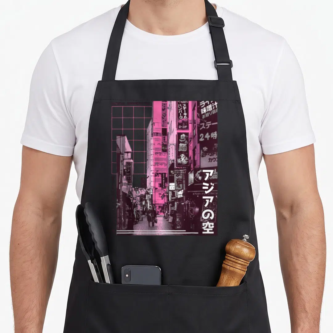 90s streetwear apron - Stylized pink and maroon cityscape with vertical Japanese text and grid overlay — shown on a black cotton canvas apron against a white background