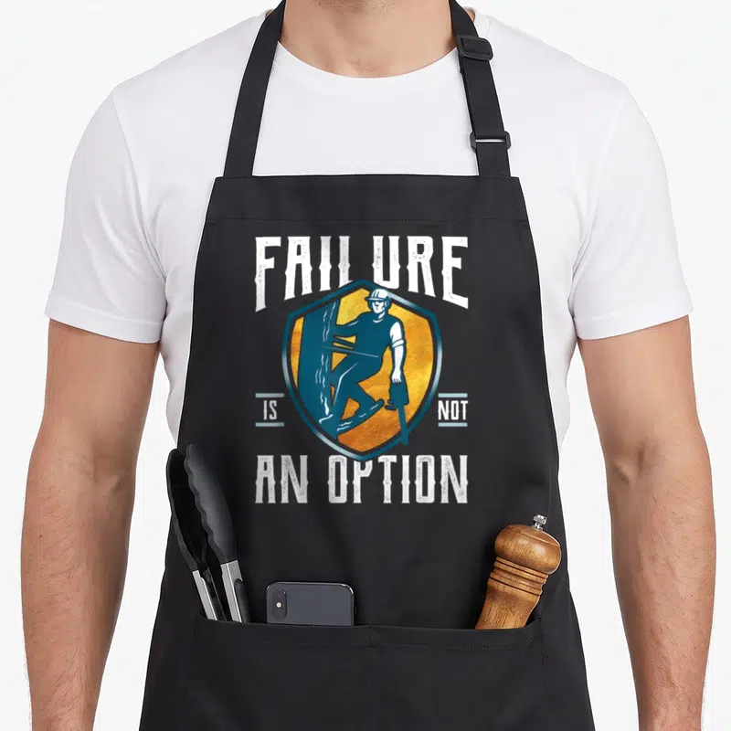 Failure tree apron - Shield with worker chainsaw text Failure Is Not An Option blue yellow white — shown on a black cotton canvas apron against a white background