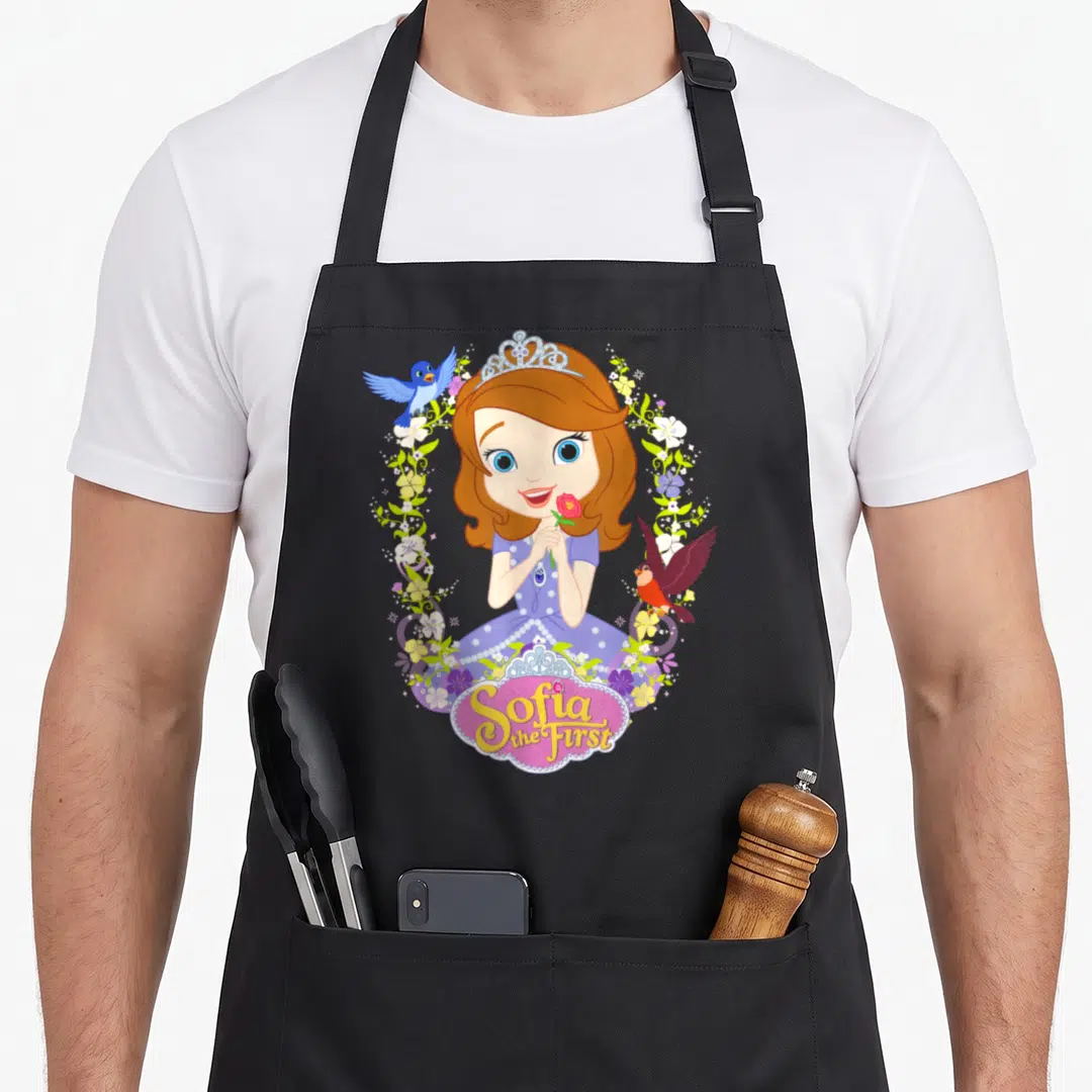 Sofia novelty apron - Princess holding pink rose in purple dress surrounded by floral wreath and birds — shown on a black cotton canvas apron against a white background