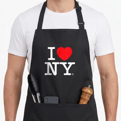 Cute new york apron - White I and NY letters with a red heart shape on grey background — shown on a black cotton canvas apron against a white background