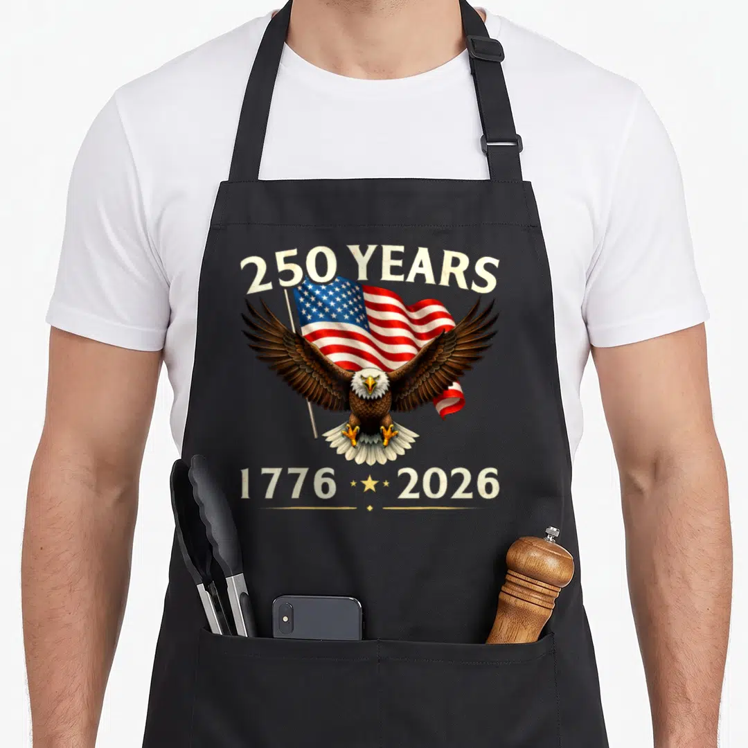 Eagle anniversary 4th of july apron - Bald eagle with spread wings holding US flag, 250 years text, 1776 and 2026 dates — shown on a black cotton canvas apron against a white background