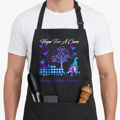Hope rheumatoid arthritis awareness apron - Gnome holding purple ribbon next to blue plaid truck and butterfly tree — shown on a black cotton canvas apron against a white background